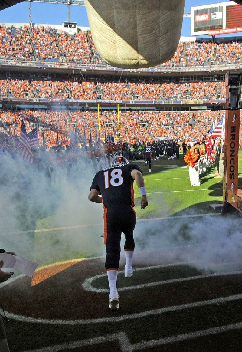 Denver Broncos quarterback Peyton Manning runs onto the field at Sports Authority Field at Mile High in Denver before Sunday’s game against the San Diego Chargers. 