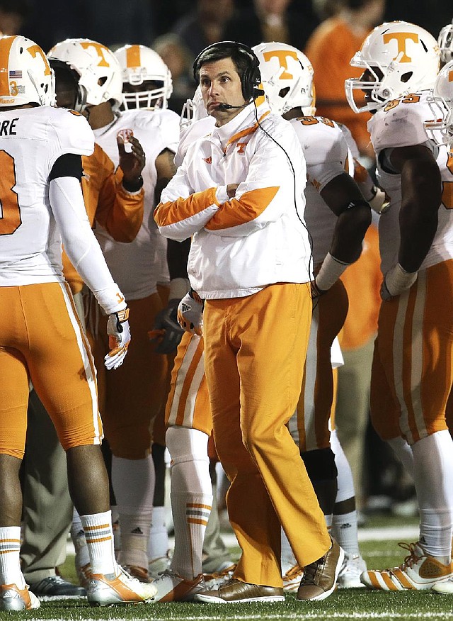Derek Dooley (center) was fired as Tennessee’s head football coach with one game remaining in his third season. Dooley (15-21) never had a winning season, going 6-7, 5-7 and 4-7. Offensive coordinator Jim Chaney will coach the Volunteers in their final regular-season game Saturday against Kentucky. 