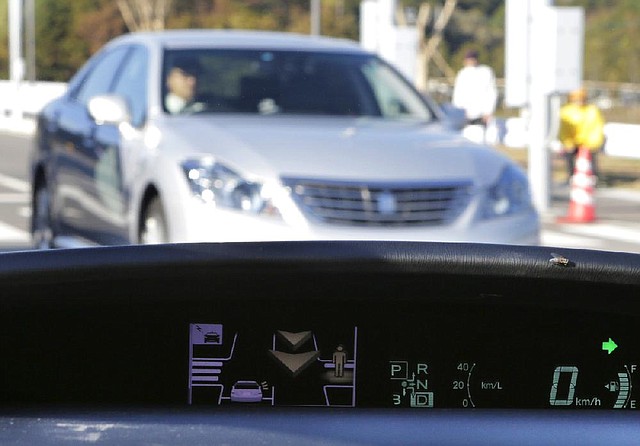 A human image and an arrow pop up on a dashboard display to warn of an approaching vehicle and a nearby pedestrian during a demonstration of Toyota’s Intelligent Transport System last week at a new center in Japan. 