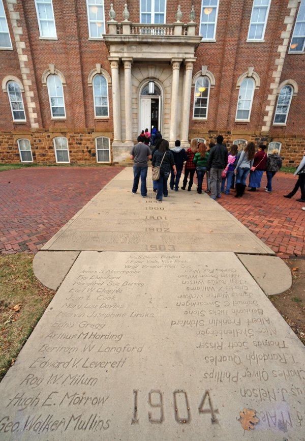 Visitors look at names on the Senior Walk in front of Old Main on the University of Arkansas campus in Fayetteville on Monday. 
