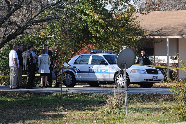 Benton County Prosecutor Van Stone and Bentonville police investigators stand outside a house on Southeast A Street, Tuesday, Nov. 20, 2012, after a missing 6-year-old girl's body was discovered. The girl was reported missing at 6:43 a.m. that morning.