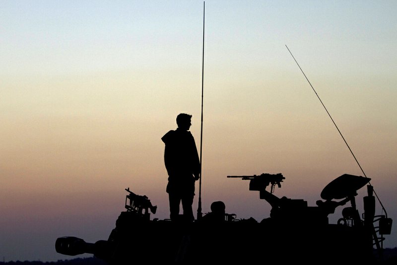 An Israeli soldier stands on top of a mobile artillery unit in a position a near the Israel Gaza border, southern Israel, on Tuesday, Nov. 20, 2012. 