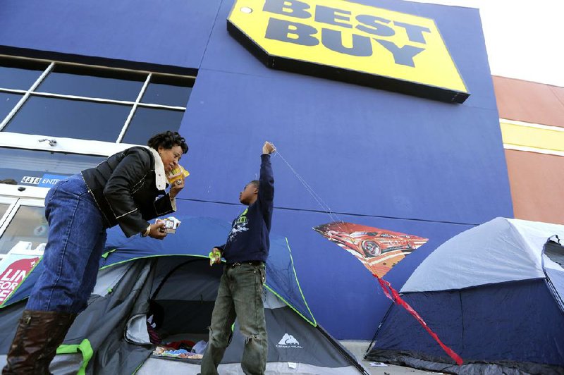 Denise Smith-Lad asks her grandson, Jordan Smith, what he would like to eat as they camped in front of a Best Buy store in Cockrell Hill, Texas, on Monday. Best Buy Co. reported a third-quarter loss Tuesday on a continued sales slump. 
