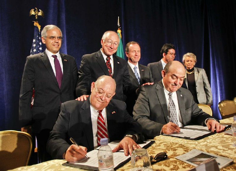 U.S. Interior Secretary Ken Salazar (center, back row) watches Tuesday in Coronado, Calif., as Mexican Commissioner Roberto Salmon (seated, left) and U.S. Commissioner Edward Drusina sign Minute 319, which is an agreement between the United States and Mexico on how water from the Colorado River will be shared by the two countries. 