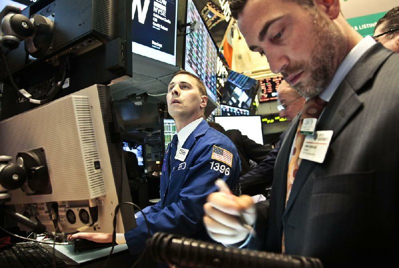 Joseph Mastrolia (left), a trader with Barclays, and Chris Casaliggii, Euronext floor manager, work Tuesday on the floor of the New York Stock Exchange. 