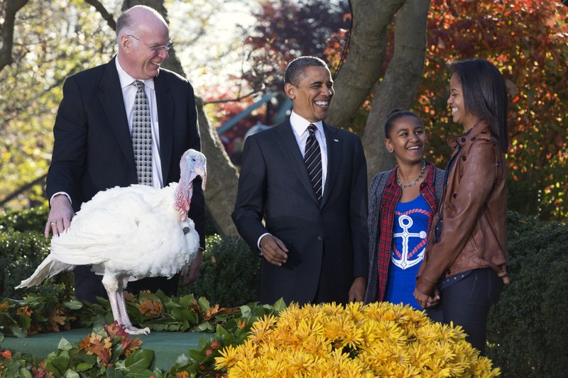 President Barack Obama, accompanied by daughters Sasha and Malia, laughs at a loud gobble from the turkey, as he pardons Cobbler a 19-week old, 40-pound turkey, on the occasion of Thanksgiving, Wednesday, Nov. 21, 2012, in the Rose Garden of the White House in Washington. At left is National Turkey Federation Chairman Steven Willardsen.