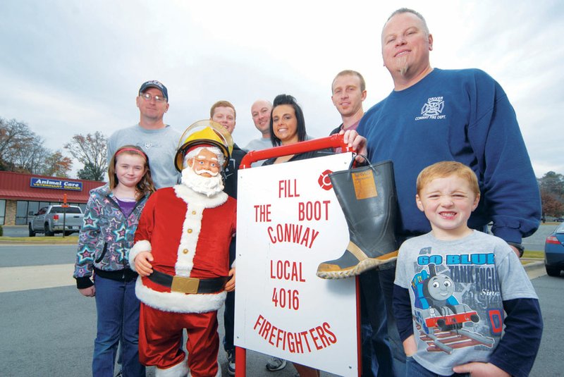 Conway firefighters and supporters getting ready for Local 4016’s 15th annual Christmas Fill the Boot campaign are, from the left, Hannah Johnson, Chad Johnson, Corbin Capps, campaign chairman Billie Carter, Rebecca Lambert, Evan Buerer, Tim Capps and Ethan Johnson. They will begin holding out boots Friday at Conway and Vilonia locations to get donations to buy toys and food for needy families.
