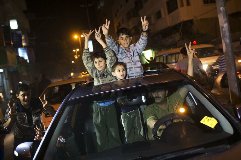 Palestinians celebrate news of the cease-fire agreement Wednesday in Gaza City that calls for Israel and Hamas to stop all hostilities, but details of how the plan will be enforced remained unclear. 