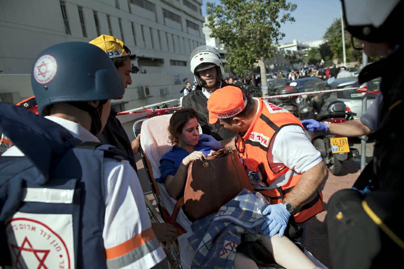 Israeli rescue workers and paramedics carry an injured woman from the site of a bombing in Tel Aviv, Israel, on Wednesday, Nov. 21, 2012. 