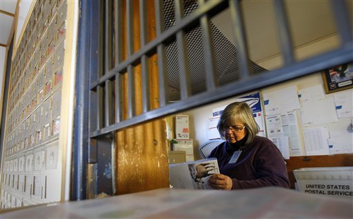 In this phot taken on Dec. 15, 2011, Postmaster Antoinette Benthusen sorts mail shortly after opening at the Post Office in Powder River, Wyo. The small, rural post office was one of 43 in Wyoming being considered for closure by the U.S. Postal Service as a cost-saving measure.