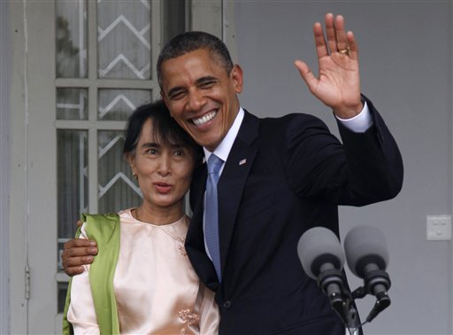 In this Nov. 19, 2012 file photo, U.S. President Barack Obama waves to the media as he embraces Myanmar opposition leader Aung San Suu Kyi after they spoke to the media at her residence in Yangon, Myanmar, Monday. The United States is unwinding two decades of sanctions against Myanmar, as the country's reformist leadership oversees rapid-fire economic and political change. Obama's visit this week, the first by a serving U.S. president, is a sign of how far relations have come. But Washington continues to take a calibrated approach to easing sanctions, keen to retain leverage should Myanmar's reform momentum stall.