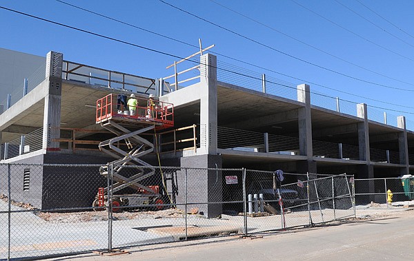 Construction crews work Wednesday on the parking deck for the 21c Museum Hotel on Northeast A Street in Bentonville. The structure is scheduled to open in the spring. A second parking deck is slated to be built in the Midtown Shopping Center. 