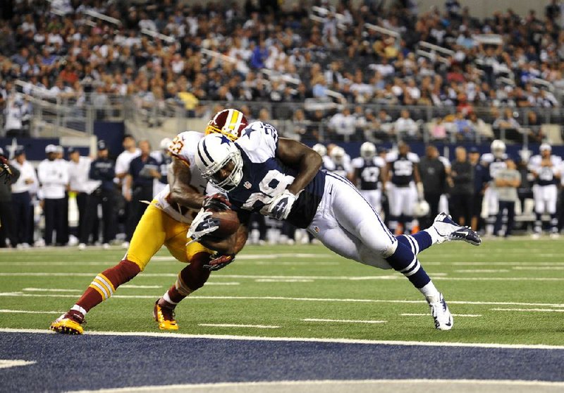 Dallas running back Felix Jones (Arkansas Razorbacks) leaps into the end zone ahead of Washington cornerback DeAngelo Hall (left) to score on a 10-yard pass during the fourth quarter of the Cowboys’ 38-31 loss to the Redskins on Thursday in Arlington, Texas. 