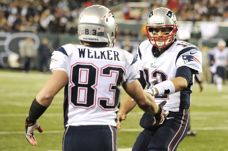 New England quarterback Tom Brady (right) congratulates receiver Wes Welker (83) after Welker caught a touchdown pass in the first half of the Patriots’ 49-19 victory over the New York Jets on Thursday in East Rutherford, N.J. 