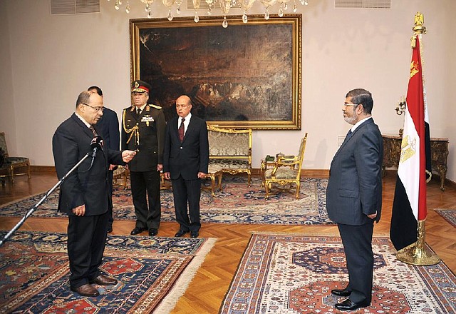 Egyptian President Mohammed Morsi (right) swears in his new prosecutor general Talaat Abdullah (left) in Cairo on Thursday, in this photo released by the Egyptian presidency. 