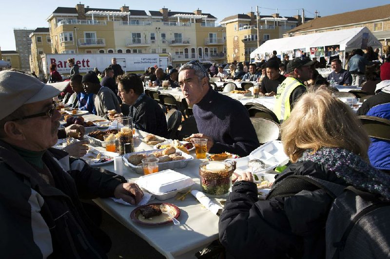 Denis Magoolaghan (right) dines on a free Thanksgiving dinner Thursday in the Rockaway section of Queens in New York. Throughout the Northeast, victims of superstorm Sandy were treated to free meals. 