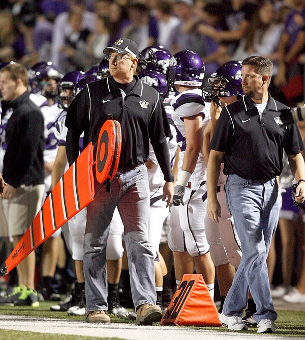 David Hook, left, and Todd Hook walk down the sideline to move the first down measuring chain and sticks
during the game between Bentonville and Fayetteville on Nov. 2 at Tiger Stadium in Bentonville.