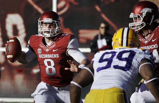 Arkansas quarterback Tyler Wilson (8) passes over LSU defensive end Sam Montgomery (99) as Arkansas offensive tackle Brey Cook, right, defends during the second quarter of an NCAA college football game in Fayetteville, Ark., Friday, Nov. 23, 2012. 