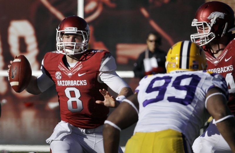 Arkansas quarterback Tyler Wilson (8) passes over LSU defensive end Sam Montgomery (99) as Arkansas offensive tackle Brey Cook, right, defends during the second quarter of an NCAA college football game in Fayetteville, Ark., Friday, Nov. 23, 2012. 