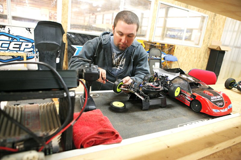 Chad Phillips works on a radio-controlled race car in the pit area of the Thunder Valley RC Raceway. The indoor racetrack holds races about twice a month with approximately 80 entrants in various divisions.  