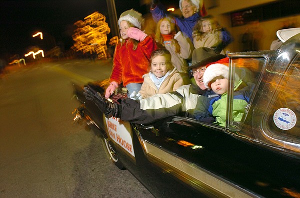 Former Springdale Mayor Jerre Van Hoose waves from a classic car during a previous Christmas parade. This year’s Christmas Parade of the Ozarks is set for 6 p.m. Saturday along Emma Avenue. 