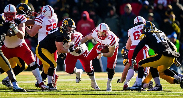 Nebraska running back Rex Burkhead (22) runs for a first down past Iowa’s Louis Trinca-Pasat (left) and Collin Sleeper (right) during the second half of the No. 14 Cornhuskers’ 13-7 victory over the Hawkeyes on Friday in Iowa City, Iowa. 