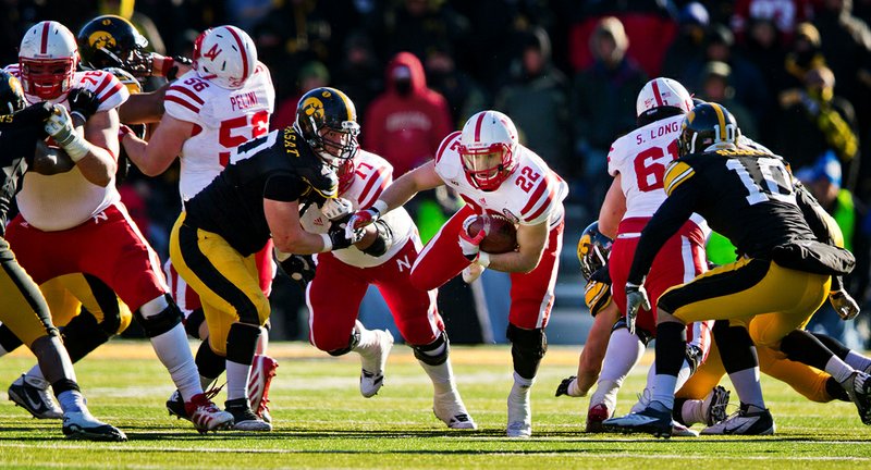 Nebraska running back Rex Burkhead (22) runs for a first down past Iowa’s Louis Trinca-Pasat (left) and Collin Sleeper (right) during the second half of the No. 14 Cornhuskers’ 13-7 victory over the Hawkeyes on Friday in Iowa City, Iowa. 