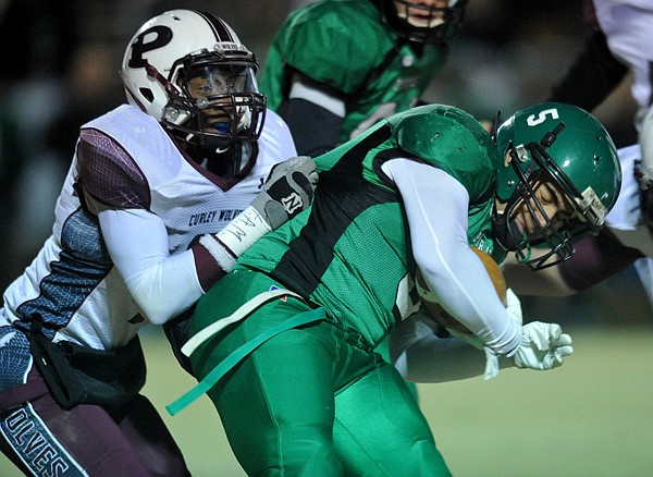 Calvin Jones, Greenland running back, is brought down Friday by Prescott defender Mark Johnson in the first half of the state playoff game in Greenland. 