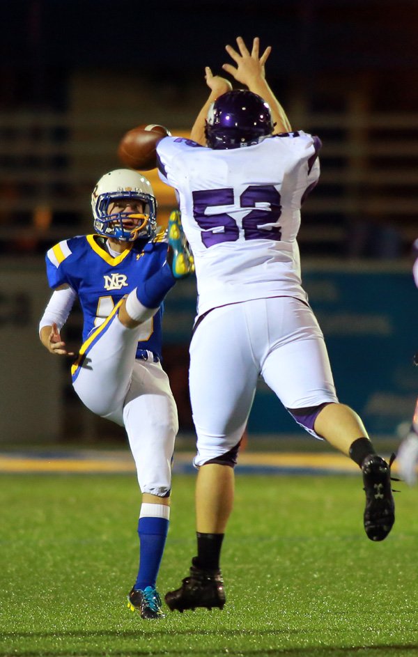 Reese Fitchue, Fayetteville, blocks a punt by North Little Rock’s Carson Ayers during the first half of their Class 7A playoff football game Friday in North Little Rock. Fitchue also recovered the ball. 