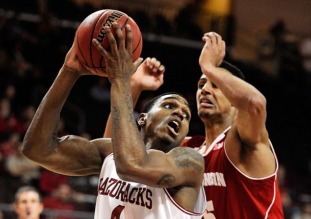 Arkansas' Coty Clarke (4) looks to make a shot with Wisconsin's Ryan Evans (5) defending during the second half of an NCAA college basketball game at the Continental Tire Las Vegas Invitational tournament on Saturday, Nov. 24, 2012, in Las Vegas. Wisconsin won 77-70. (AP Photo/David Becker)