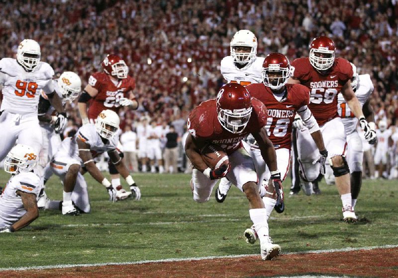 Oklahoma running back Brennan Clay (middle) scores the game-winning touchdown to give the No. 13 Sooners a 51-48 overtime victory over No. 21 Oklahoma State on Saturday in Norman, Okla. 