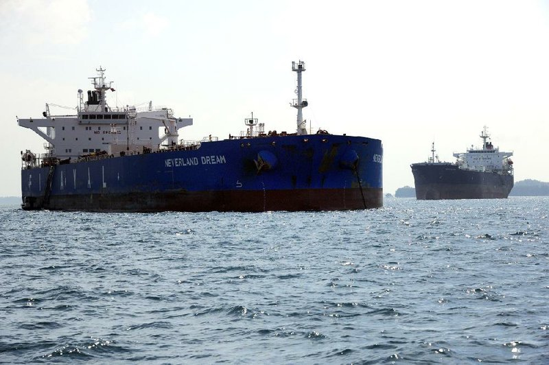 Finaval SpA’s Neverland Dream oil tanker (left) is seen in Singapore, Asia’s largest oil-trading-and-storage center. Customs data show Iranian oil shipments to Asia have increased since the West tightened sanctions in July. 