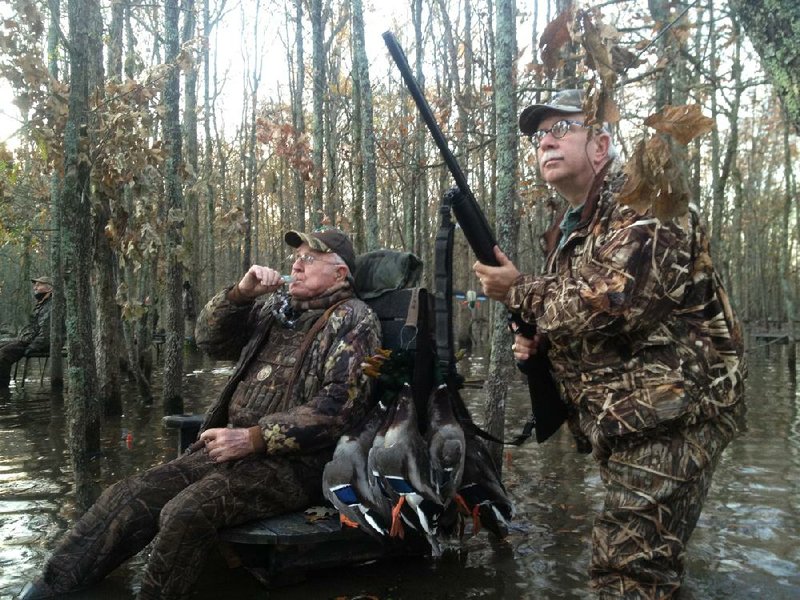 Wiley Meacham (left) calls to a flock of mallards while North Carolina judge Talmage Baggett (right) watches Monday during a hunt at Meacham’s farm in Lee County. 