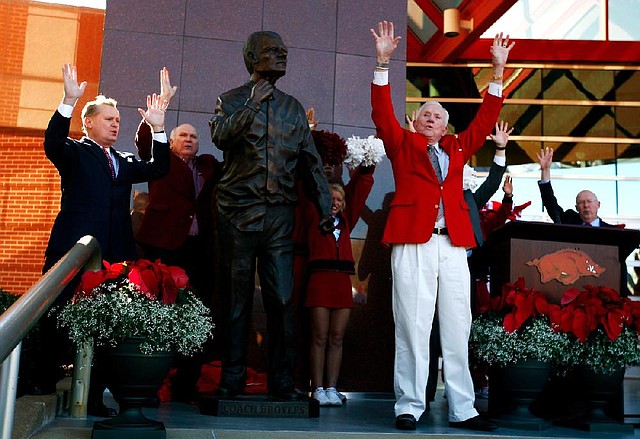 Former Arkansas Coach and Athletic Director Frank Broyles calls the Hogs on Friday during a ceremony unveiling a statue in his honor outside the Broyles Athletic Center in Fayetteville. 
