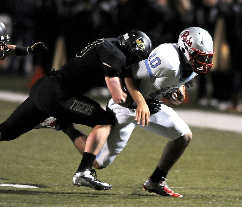 Bentonville linebacker Garrett Kaufman (left) tackles Fort Smith Southside quarterback Isaac Jackson during Friday night’s Class 7A playoff game. 