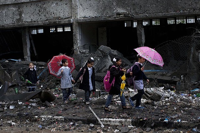 Palestinian schoolchildren walk through rubble at their school in Gaza City as schools reopened for the first time since the Israeli-Hamas truce took hold. The school was damaged when Israelis struck a nearby building during eight days of fighting. 