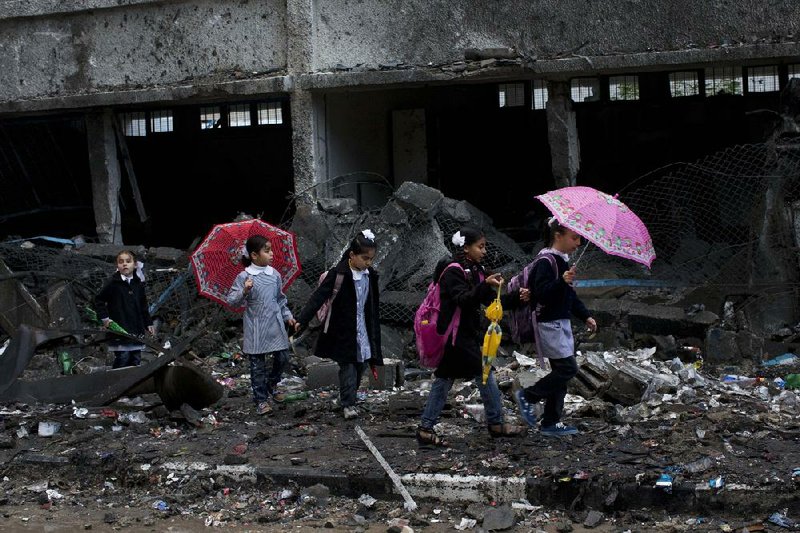Palestinian schoolchildren walk through rubble at their school in Gaza City as schools reopened for the first time since the Israeli-Hamas truce took hold. The school was damaged when Israelis struck a nearby building during eight days of fighting. 