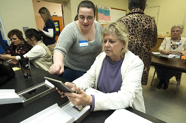 Emma Santoy (left), an employee with Barnes & Noble, helps Suzzette Patterson use a Nook ereader. 