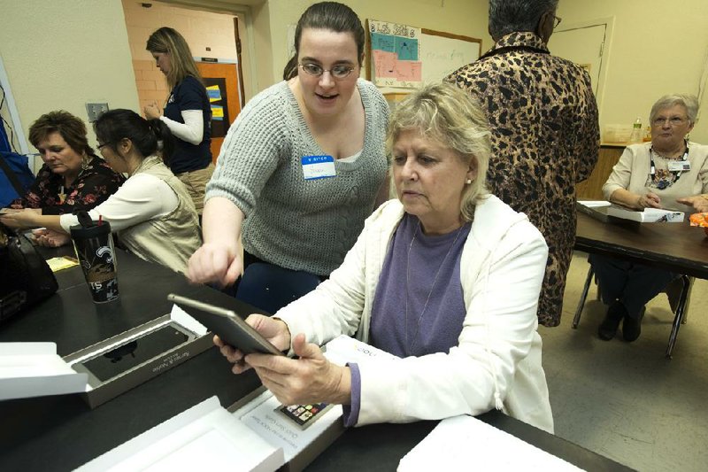 Emma Santoy (left), an employee with Barnes & Noble, helps Suzzette Patterson use a Nook ereader. 