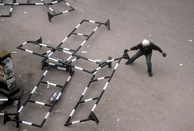 An Egyptian protester drags a security barrier during clashes Saturday outside that country’s high court in Cairo. 