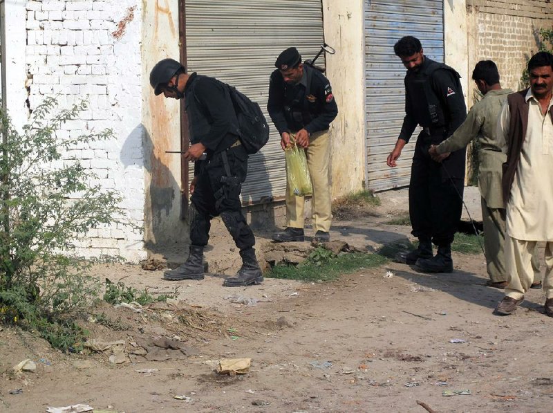 Police collect evidence Saturday at the site of a fatal bombing in Dera Ismail Khan, Pakistan. 