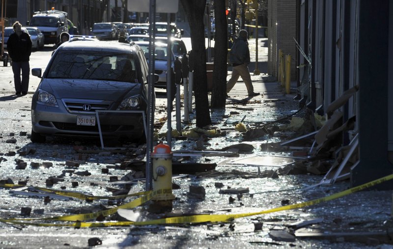 People walk in a damaged area about a block away from the site of a Friday-evening gas explosion that leveled a strip club in Springfield, Mass., Saturday, Nov. 24, 2012. Investigators are trying to figure out what caused the blast where the multistory brick building housing Scores Gentleman's Club once stood. 