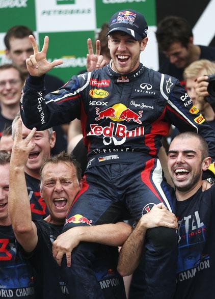 Red Bull driver Sebastian Vettel (center) celebrates after clinching his third consecutive Formula One championship Sunday. Vettel finished sixth in the Brazilian Grand Prix in Sao Paulo. Jenson Button won the race. 