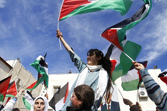 Palestinian schoolgirls wave Palestinian flags during a rally Sunday in the West Bank city of Ramallah supporting the Palestinian bid for observer status. 
