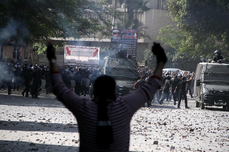 Egyptian security forces, background, clash with protesters near Tahrir Square in Cairo on Sunday, Nov. 25, 2012. 