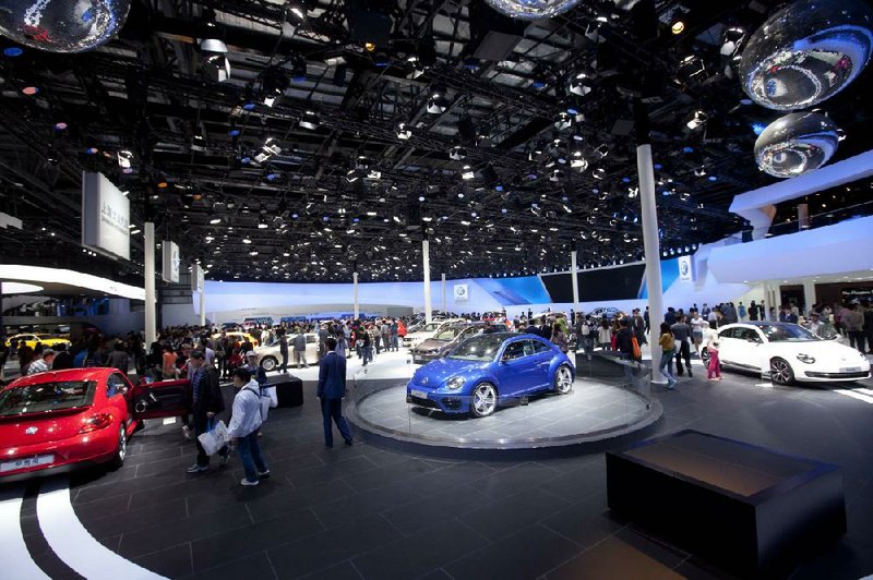 Visitors look at Volkswagen vehicles at an auto show in Beijing in April. Volkswagen executives say the company will continue to open new dealerships in China’s smaller cities. 
