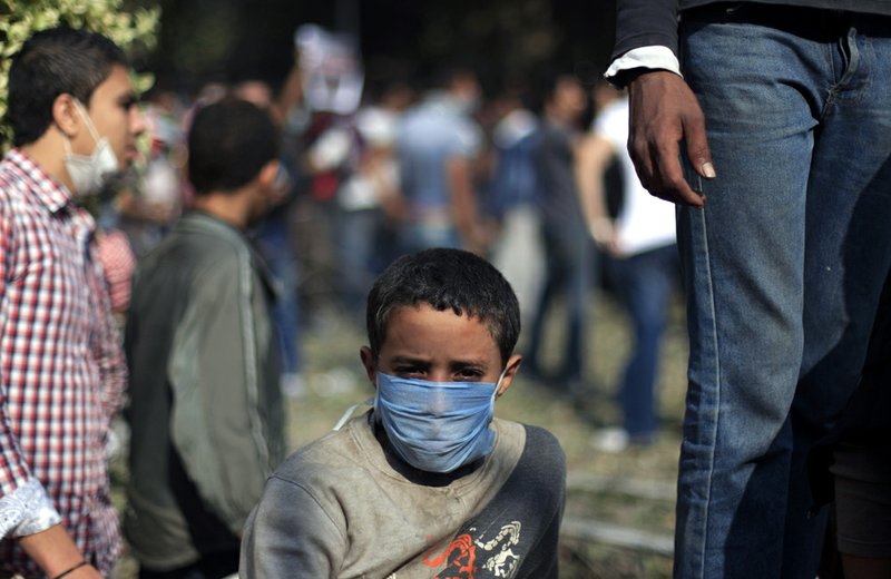 An Egyptian boy wears a mask during clashes security forces near Tahrir square, where an opposition rally has been called for to voice rejection of President Mohammed Morsi's seizure of near absolute powers in Cairo on Tuesday, Nov. 27, 2012. 