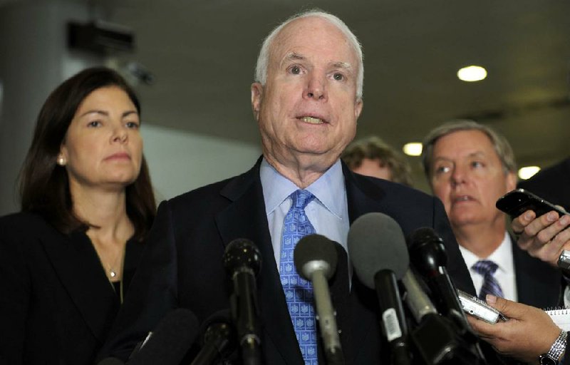 Sen. John McCain, R-Ariz., ranking Republican on the Senate Armed Services Committee, flanked by fellow committee members Sen. Kelly Ayotte (left), R-N.H., and Sen. Lindsey Graham, R-S.C., speaks on Capitol Hill in Washington on Tuesday after a meeting with Susan Rice. 