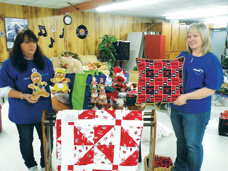 Volunteers Jodi Jones, left, representing Hewlett-Packard, and Judy Tipton, representing Acxiom Corp., lend a hand Monday afternoon in decorating the Conway Senior Wellness and Activity Center, formerly known as the Conway Senior Citizen Center. The center will host its 32nd annual pancake breakfast, silent auction, craft and bake sale from 7 a.m. to noon Saturday, with all proceeds benefiting the Faulkner County Senior Citizens Program. The handmade Arkansas Razorback quilt and pillow will be given away during a drawing.