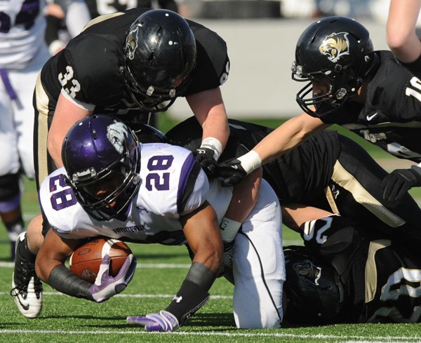 Brice Gahagans, a Fayetteville junior running back, is tackled by Bentonville linebacker Garrett Kaufman during last year’s Class 7A state championship game in War Memorial Stadium in Little Rock. The two players return for the third consecutive title showdown between the two Northwest Arkansas rivals Saturday night. 